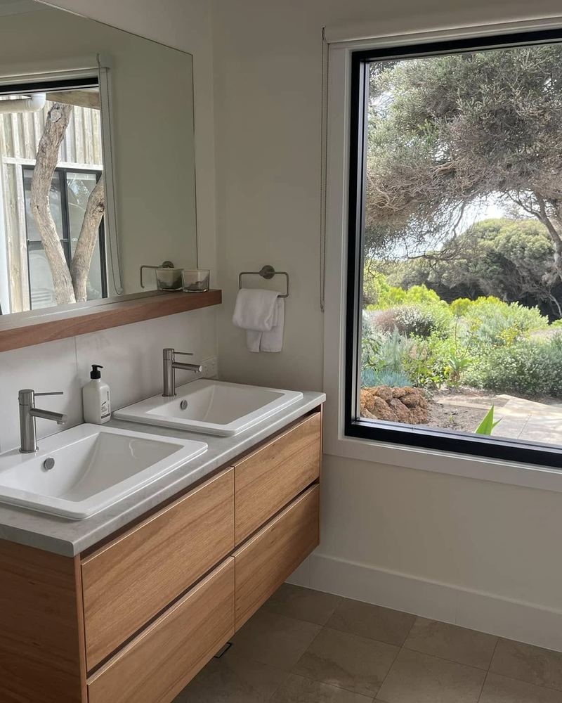 Finished bathroom with a double timber vanity and a big window